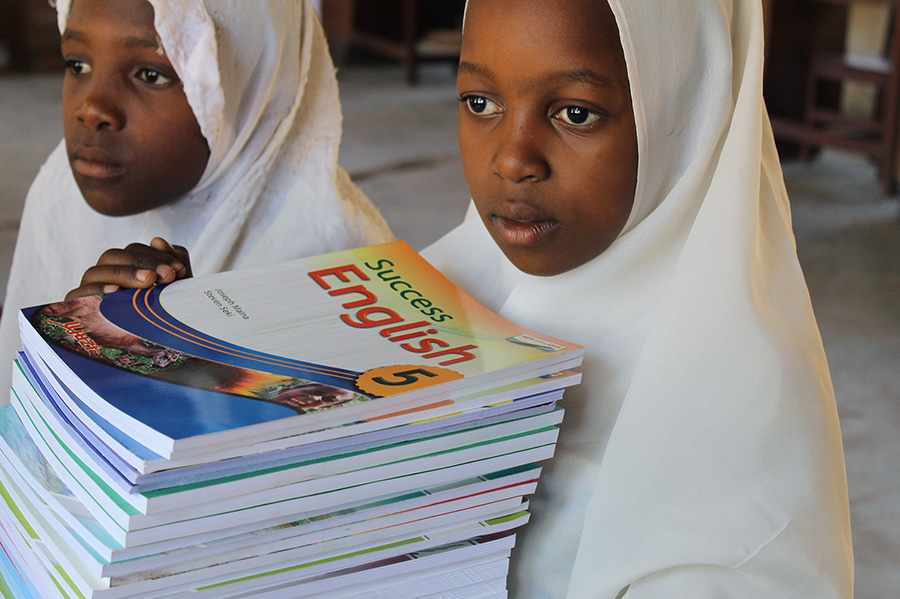 Pupils of Mkuti primary school holding books, project funded by African Palms selling palm crosses