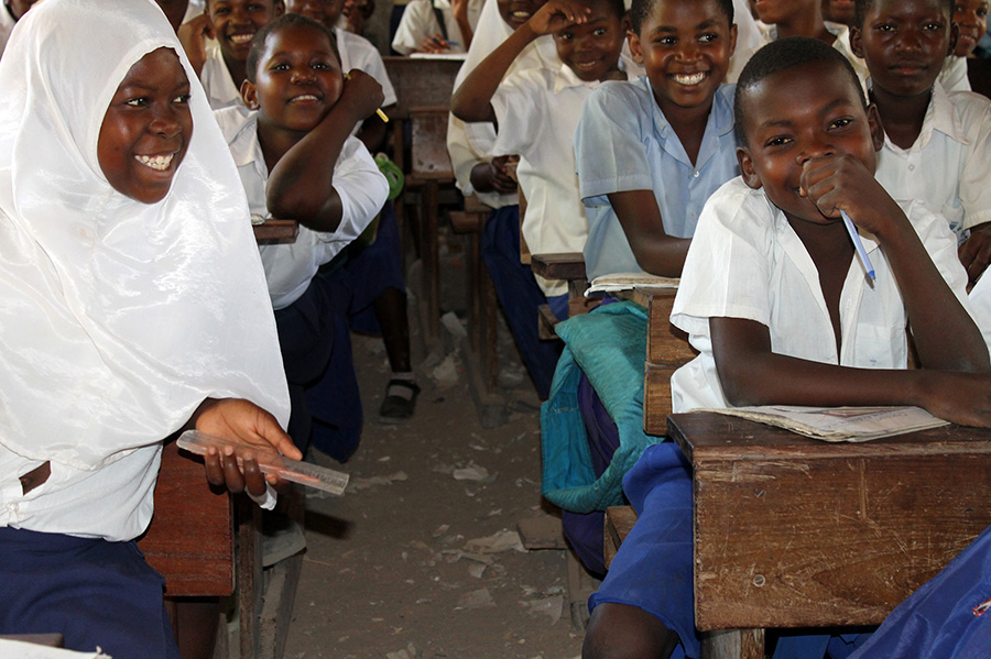 Pupils of Mkuti primary in a happy mood after receiving books, project funded by African Palms selling palm crosses